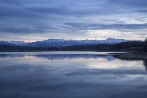 a large body of water with mountains in the background at L'Oasis Des Pyrénées in Campuzan