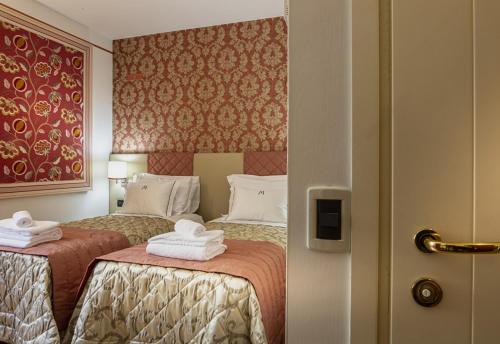 Pove del Grappa的住宿－HOTEL MIRAMONTI ENOTECA，酒店客房,配有两张带毛巾的床