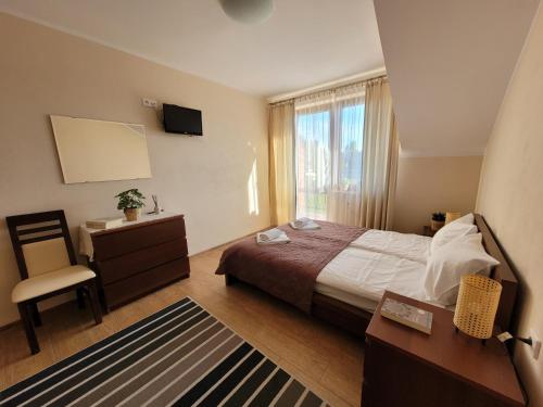 a bedroom with a bed and a desk and a television at Pokoje i apartamenty "U Beaty" in Karwia