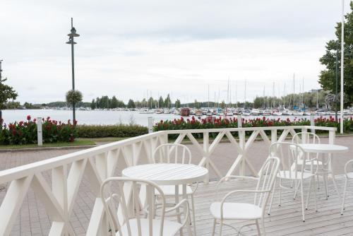a row of tables and chairs on a balcony with a marina at Boutique Hotel Lähde in Lappeenranta