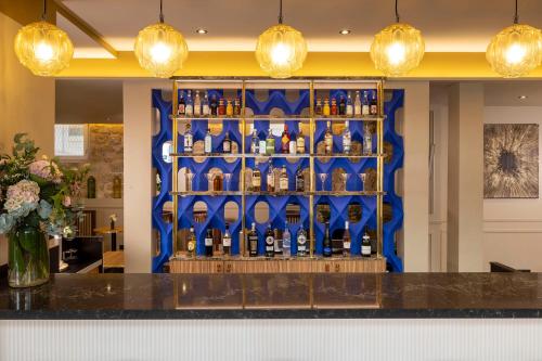 a display of bottles of wine on a blue wall at Hotel Le Rocroy in Paris