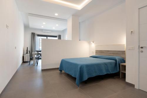 a bedroom with a bed with a blue blanket at Apartamento Virgen de la Luz 4 in Conil de la Frontera