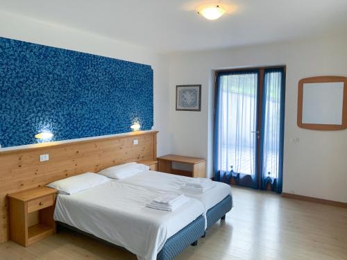 1 dormitorio con 1 cama grande y pared azul en Agritur al Vigneto, en Trento