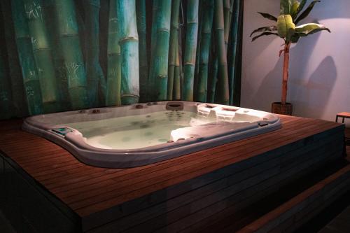 Bed & Wellness Boxtel في بوكستيل: وجود حوض استحمام على طاولة خشبية