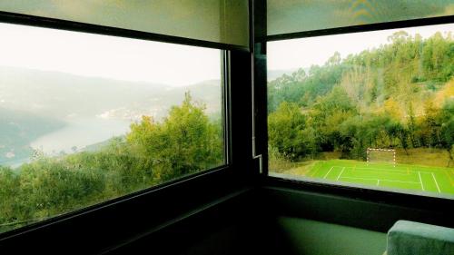 uma vista para um campo de ténis a partir de uma janela em ArsDurium Douro hotel em Cinfães