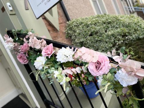 a bunch of pink and white flowers on a balcony at Abbey House B & B in Penrith