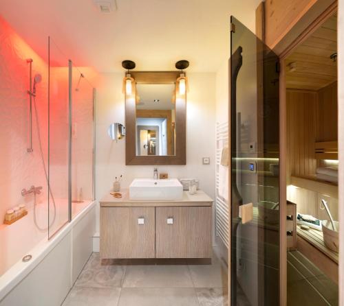 a bathroom with a sink and a mirror at Résidence Pierre & Vacances Premium L'Hévana in Méribel