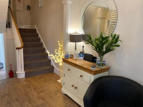 a living room with a dresser and a mirror at Abbey House B & B in Penrith