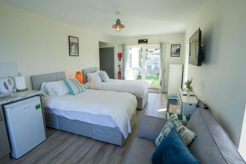 a bedroom with two beds and a couch at The Gaslight Inn Holiday Apartments & Licenced Restaurant Rossnowlagh in Rossnowlagh