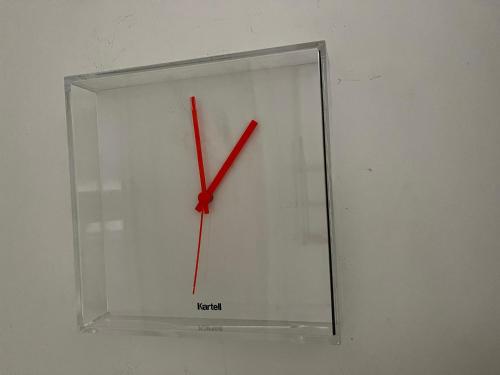 a clock with red hands is hanging on a wall at Design Guesthouse Laanila in Oulu