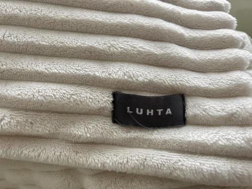 a stack of white towels with a sign on them at Design Guesthouse Laanila in Oulu