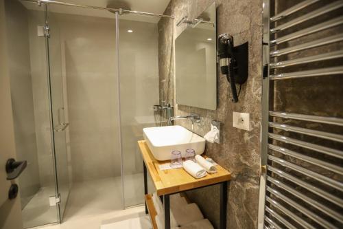 a bathroom with a sink and a shower at Urbanin Apartment & Hotel in Tirana