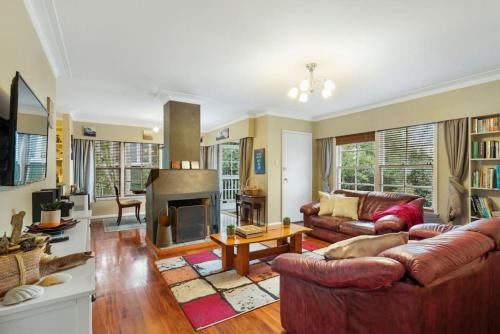 a living room with two couches and a fireplace at Kohi Family Home With Netflix l Gardens View in Auckland