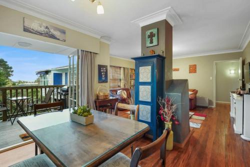 a living room with a table and a balcony at Kohi Family Home With Netflix l Gardens View in Auckland