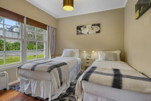 a bedroom with two beds and a window at Kohi Family Home With Netflix l Gardens View in Auckland