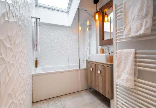 a bathroom with a shower and a tub and a sink at Résidence Pierre & Vacances Premium L'Hévana in Méribel