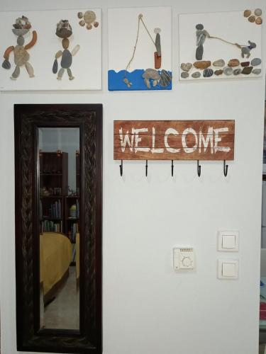 a mirror on a wall with a welcome sign at PUZZLE SWEET HOME in Serres
