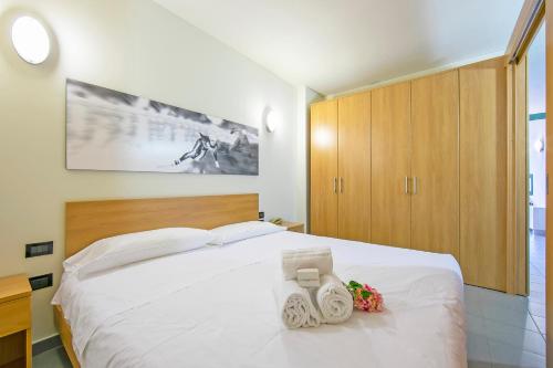 a bedroom with a white bed and wooden cabinets at Villaggio Olimpico in Sestriere