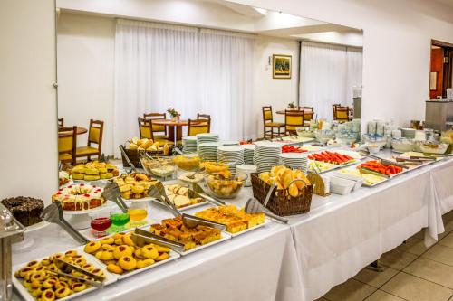 uma linha de buffet com muitos tipos diferentes de alimentos em Hotel Itapema em Valinhos