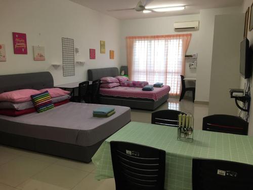 Sala de estar con 2 camas y mesa en Azin Ramli Studio, en Seri Kembangan