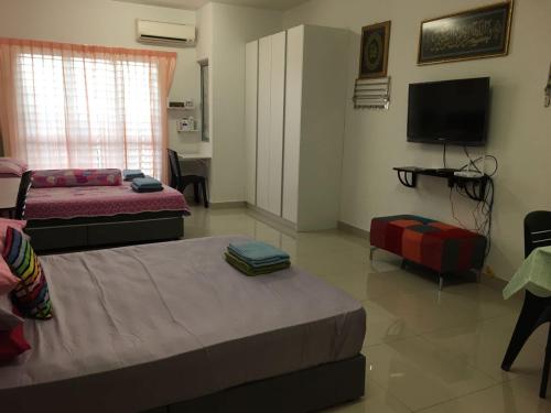 um quarto com duas camas e uma televisão e um sofá em Azin Ramli Studio em Seri Kembangan
