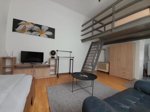 ein Wohnzimmer mit einem Hochbett und einem Sofa in der Unterkunft Főtér Apartman Baja in Baja