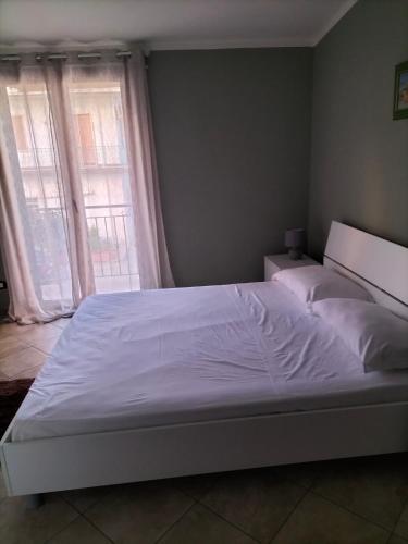 a bedroom with a large white bed with two windows at Borghetto Verde in Locri