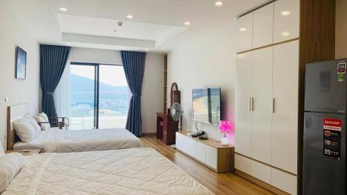 a bedroom with two beds and a large window at Condotel TMS HOÀNG GIA VIEW BIỂN, TÒA NHÀ CAO NHẤT QUY NHƠN in Quy Nhon