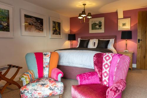 1 dormitorio con 1 cama y 2 sillas en West Lyn Farm en Lynton