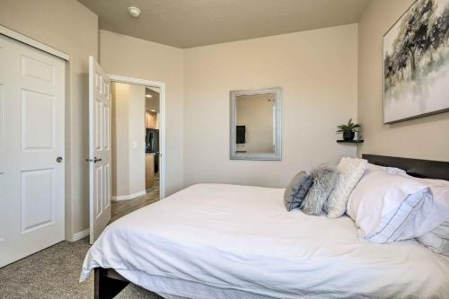 a bedroom with a white bed and a mirror at Mesquite Desert Retreat Near Golf and Casinos! in Mesquite