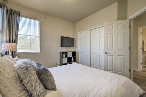 a bedroom with a white bed and a television at Mesquite Desert Retreat Near Golf and Casinos! in Mesquite