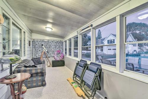 a room with two chairs and a table and windows at East Tawas Cabin with Lake Huron Access and Views in East Tawas