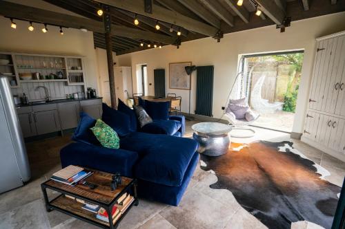 a living room with a blue couch and a table at The Chicken Shed at Knowle Top in Clitheroe