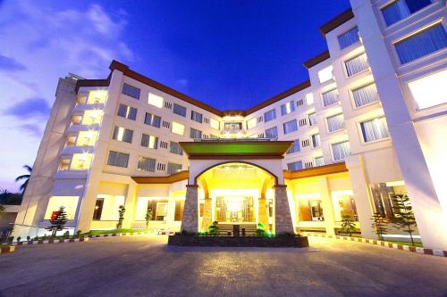 a large white building with a courtyard at night at Zurich Hotel Balikpapan in Balikpapan