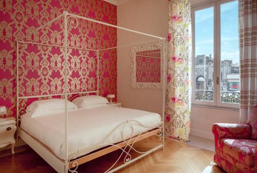 Schlafzimmer mit Himmelbett und roten Wänden in der Unterkunft Luxury Villa Manin Viareggio | UNA Esperienze in Viareggio