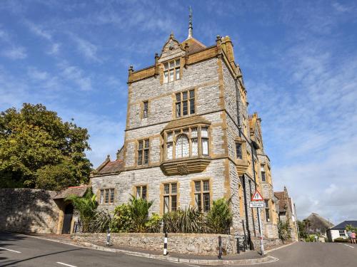 an old stone building on the side of a street at 3 Coram Tower in Lyme Regis