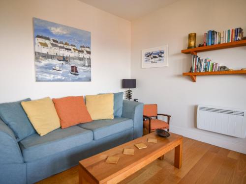 a living room with a blue couch and a coffee table at 3 Coram Tower in Lyme Regis