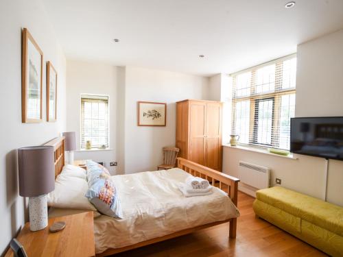 a small bedroom with a bed and a couch at 3 Coram Tower in Lyme Regis