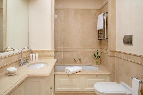 ein Badezimmer mit einem Waschbecken, einem WC und einem Spiegel in der Unterkunft Luxury Villa Manin Viareggio | UNA Esperienze in Viareggio
