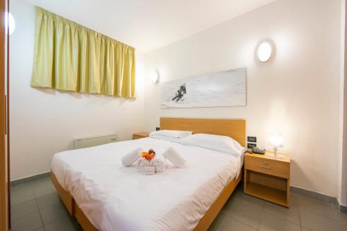 a bedroom with a large white bed with flowers on it at Villaggio Olimpico in Sestriere