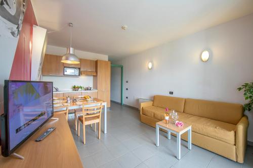 a living room with a couch and a tv and a kitchen at Villaggio Olimpico in Sestriere
