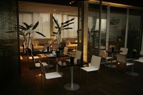 a dining room with white chairs and tables and a couch at Kemang Icon in Jakarta