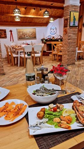 a wooden table with plates of food on it at Hotel Dollari in Durrës