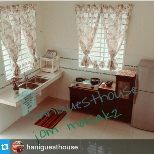 a small kitchen with a sink and a refrigerator at Hani Guest House Big House in Malacca
