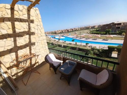 a balcony with chairs and a view of a pool at Chalet Marina Wadi Degla Families Only Pool view 2nd floor 6 adults in Ain Sokhna