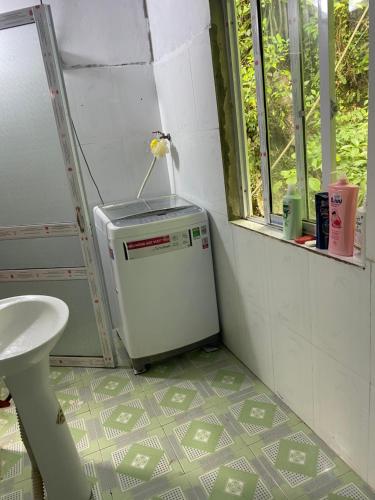 a bathroom with a small refrigerator and a sink at Tuệ Nhi Homestay Ngườm Ngao Bản Giốc in Cao Bằng