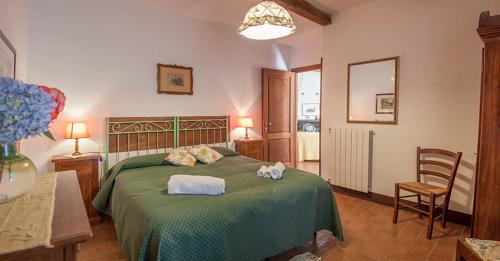 a bedroom with a green bed with towels on it at Castello Santa Cristina in Grotte di Castro