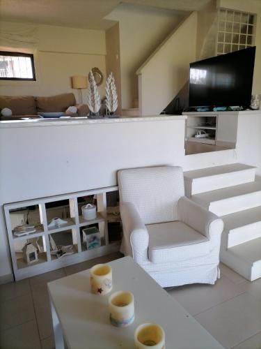 a living room with two chairs and a tv at Summer House @Fourka Beach in Skala Fourkas