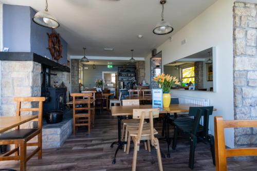 a restaurant with wooden tables and chairs and a fireplace at The Gaslight Inn Self Catering Holiday Apartments Rossnowlagh Donegal in Rossnowlagh