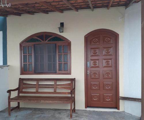 two doors and a bench in front of a house at Casa agradável in Cabo Frio